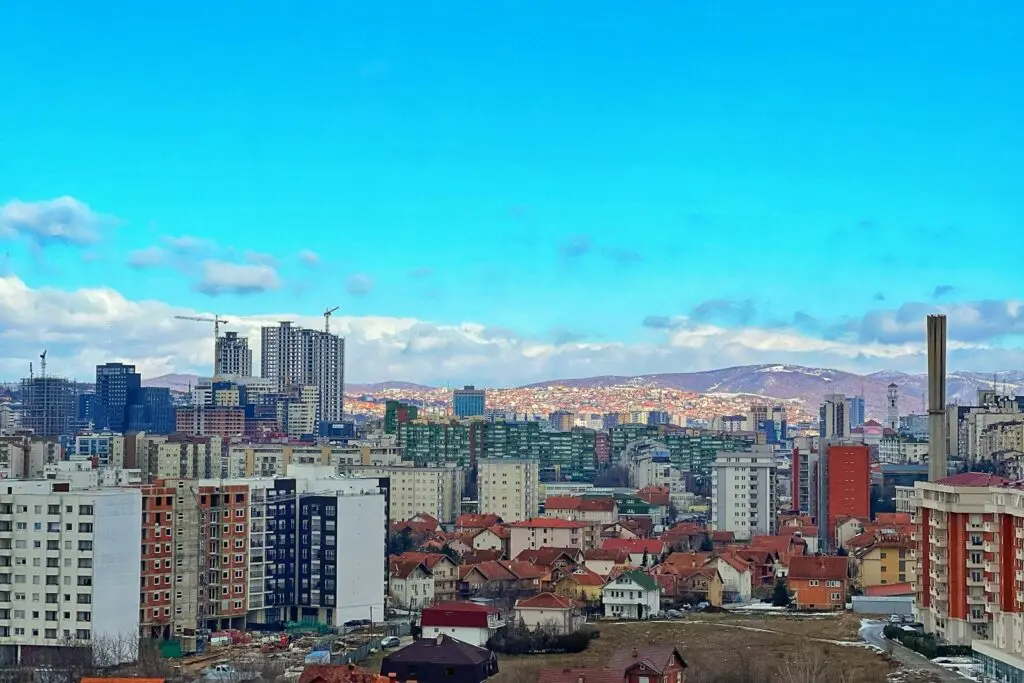 Veduta di Pristina con gli edifici del centro e le colline circostanti